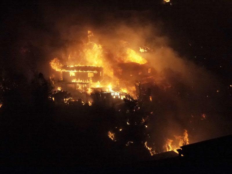 Nicht mehr zu retten: Ein Haus wird zum Raub der Flammen. Foto: EPA