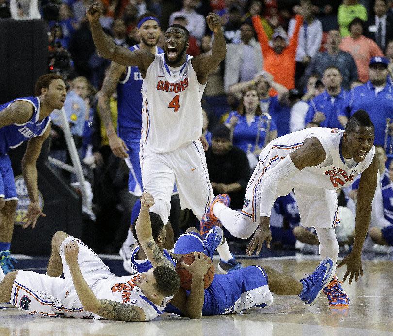 Florida center Patric Young (4) celebrates with Florida forward Will Yeguete (15) after the second half of an NCAA college basketball game against Kentucky in the Championship round of the Southeastern Conference men's tournament, Sunday, March 16, 2014, in Atlanta. Florida won 61-60. (AP Photo/Steve Helber)