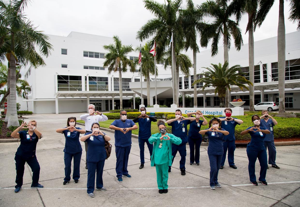 Rich Helvey, rear in white coat and pink mask, oversees about 70 employees in environmental services at Cape Coral Hospital. His employees show their love after an eight-hour shift on Monday, April 20, 2020, that includes cleaning rooms with COVID-19 patients.