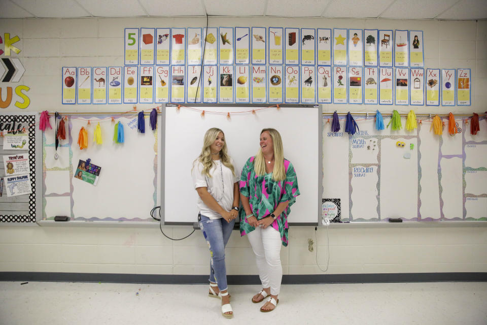 First grade teachers, Ellie Morgan, 25, left, Hannah Sprayberry, 28, right, pose for a portrait, and say they are taking around 5 per-cent pay cut on Thursday, May 28, 2020, in Fort Oglethorpe, Ga. With sharp declines in state spending projected because of the economic fallout from the COVID-19 pandemic, America's more than 13,000 local school systems are wrestling with the likelihood of big budget cuts. (AP Photo/Brynn Anderson)