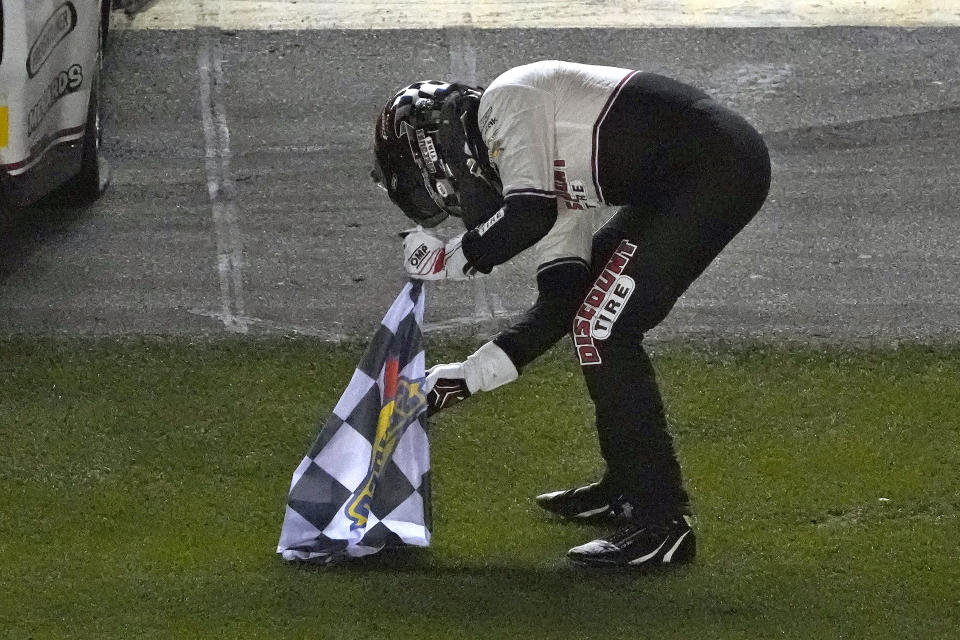 Austin Cindric plants the checkered flag in to the grass after winning the NASCAR Daytona 500 auto race Sunday, Feb. 20, 2022, at Daytona International Speedway in Daytona Beach, Fla. (AP Photo/Chris O'Meara)