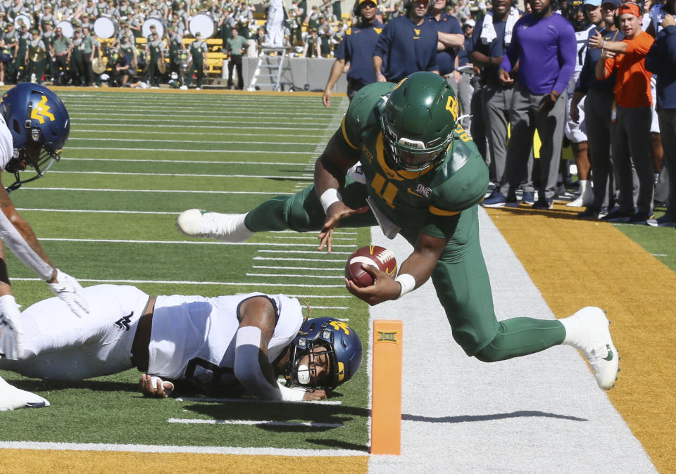 Baylor quarterback Gerry Bohanon is knocked out of bounds short of the goal line as West Virginia linebacker VanDarius Cowan defends in the first half of an NCAA college football game, Saturday, Oct. 9, 2021, in Waco, Texas. He would score on the next play. (Rod Aydelotte/Waco Tribune-Herald via AP)