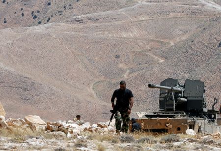 A Hezbollah fighter walks holding his weapon at Juroud Arsal, Syria-Lebanon border, July 25, 2017. REUTERS/Mohamed Azakir