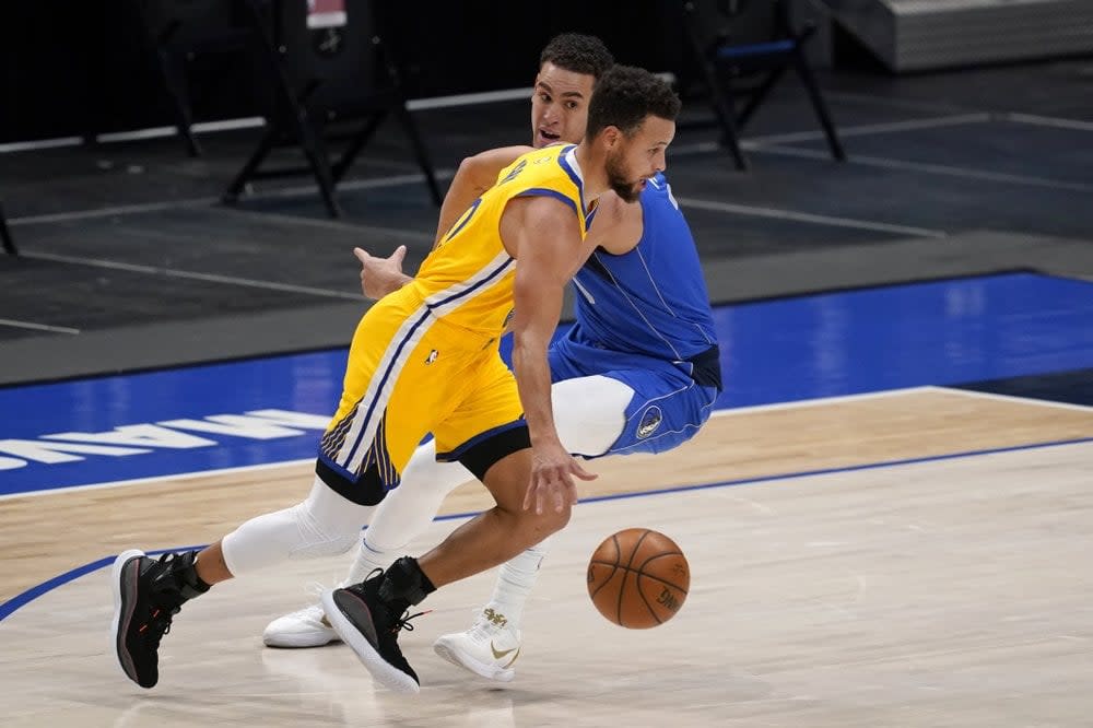 Golden State Warriors guard Stephen Curry (30) drives past Dallas Mavericks’ Dwight Powell on his way to the basket during the first half of an NBA basketball game in Dallas, Thursday, Feb. 4, 2021. (AP Photo/Tony Gutierrez)