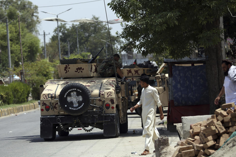 Personal de seguridad afgano reunido ante una prisión atacada en la ciudad de Jalalabad, al este de Kabul, Afganistán, el lunes 3 de agosto de 2020. (AP Foto/Rahmat Gul)