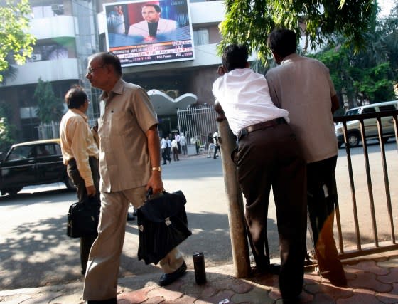 People look at a large screen displaying India's benchmark share index on the facade of the Bombay Stock Exchange building in Mumbai on Nov. 20, 2008. India's main share index fell 3.7 percent on Thursday to its lowest close in more than three years, as jittery investors crammed the exit as a broad sell-off gripped world markets on a worsening global economy. <span class="copyright">Arko Datta—Reuters</span>