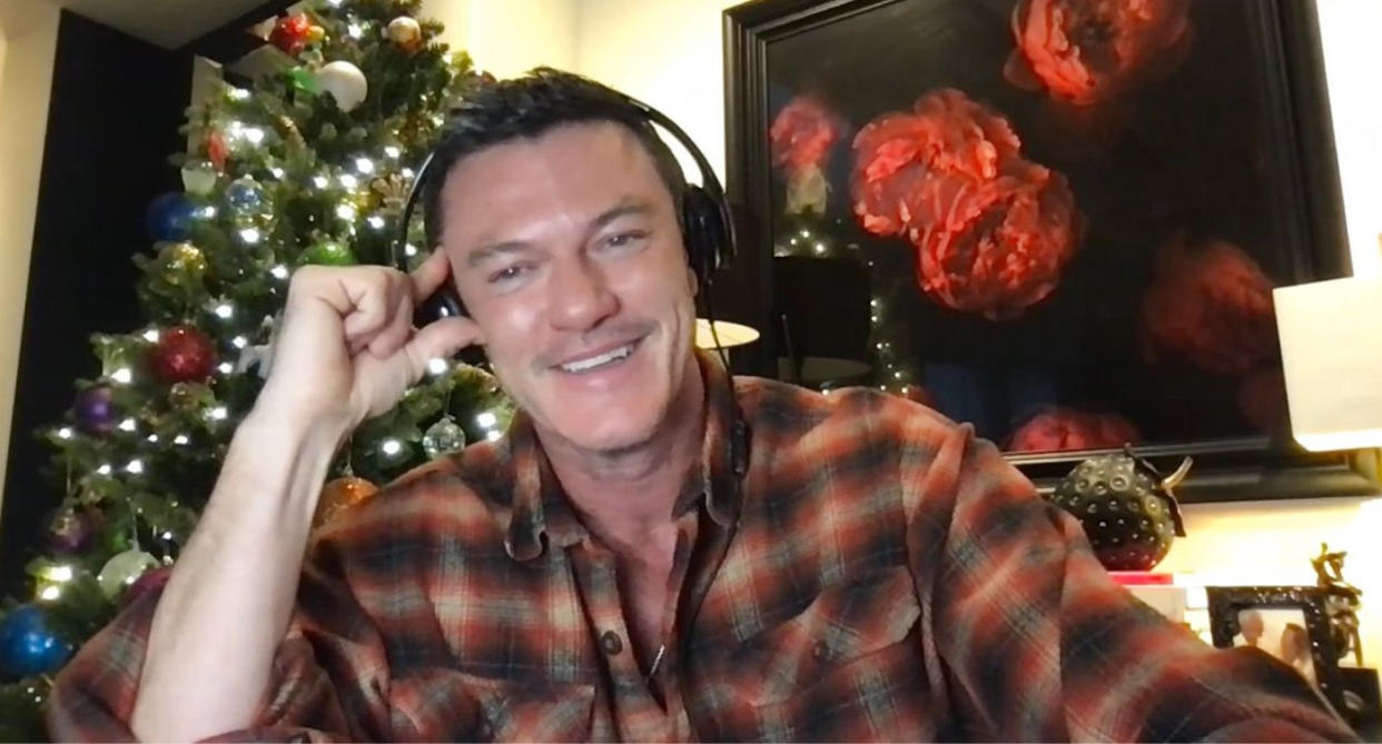 Luke Evans being interviewed for podcast White Wine Question Time with Christmas tree in background. (White White Question Time)