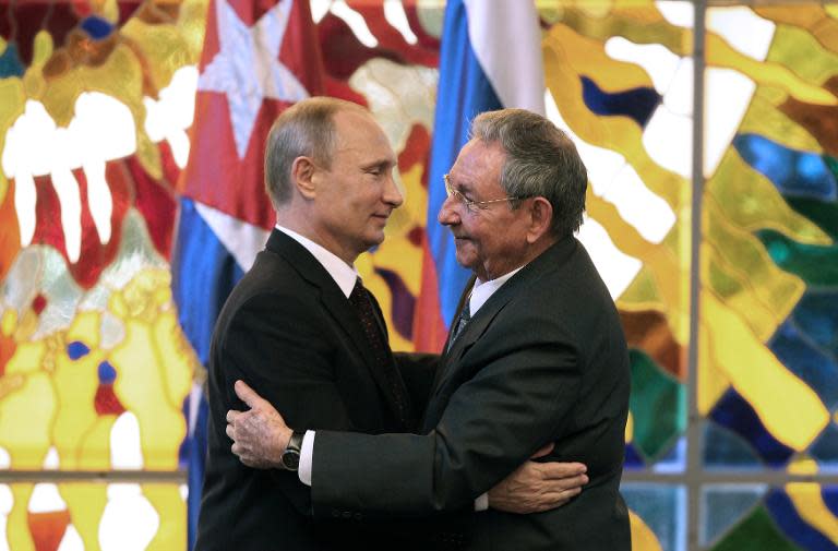 Russian President Vladimir Putin (L) and his Cuban counterpart Raul Castro greet each other at Revolution Palace in Havana, on July 11, 2014