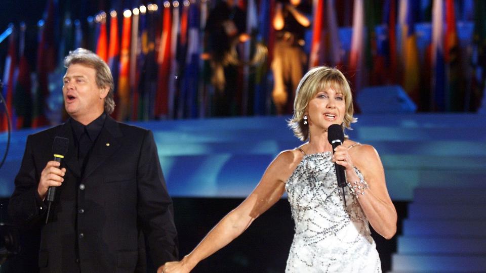 SYDNEY, AUSTRALIA: Australian singer Olivia Newton-John, wearing diamonds to the value of 1.6 million (US) dollars, and John Farnham sing "Dare to Dream" before the assembled athletes during the opening ceremony of the 2000 Summer Olympics in Sydney 15 September 2000. AFP PHOTO/TIMOTHY CLARY (Photo credit should read TIMOTHY CLARY/AFP/Getty Images)