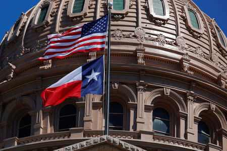 The U.S flag and the Texas State flag fly over the Texas State Capitol as the state senate debates the #SB6 bathroom bill in Austin, Texas, U.S., March 14, 2017. REUTERS/Brian Snyder