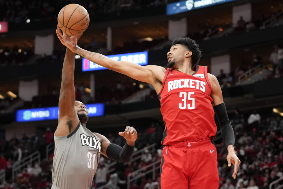 Houston Rockets center Christian Wood (35) and Brooklyn Nets forward Paul Millsap go for a rebound during the first half of an NBA basketball game, Wednesday, Dec. 8, 2021, in Houston. (AP Photo/Eric Christian Smith)