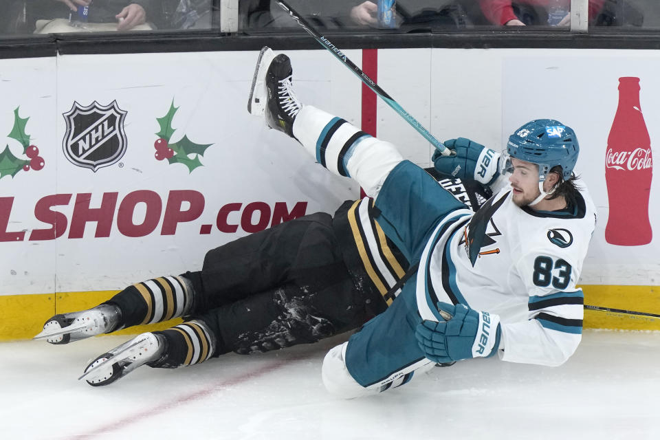 San Jose Sharks defenseman Nikita Okhotiuk (83) and Boston Bruins center Morgan Geekie, behind, crash into the boards after colliding in the second period of an NHL hockey game, Thursday, Nov. 30, 2023, in Boston. (AP Photo/Steven Senne)