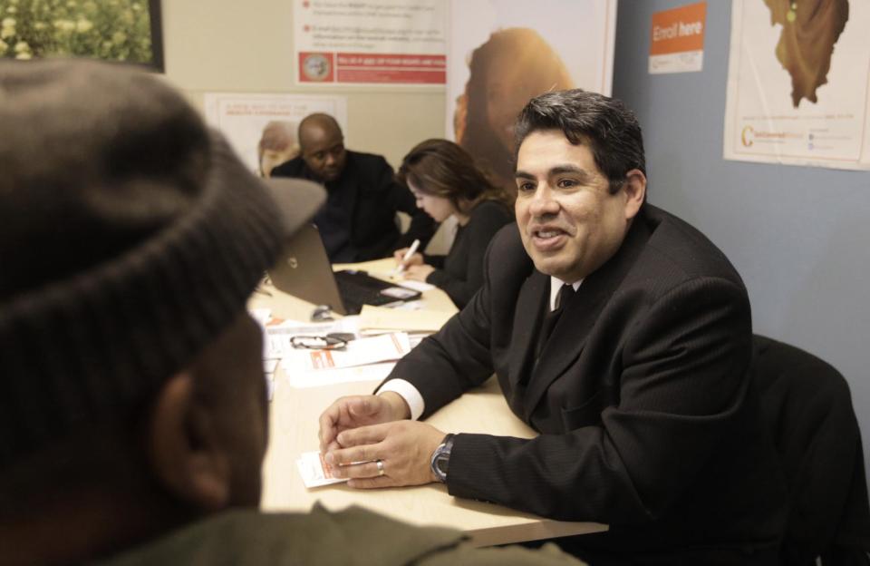 In this Feb. 3, 2014, photo, Salvador Cerna, an Illinois outreach coordinator for President Obama's new health care law speaks to a taxi driver at a city office where Chicago taxi drivers go to renew their license. "We have a captive audience,” said Cerna, “Instead of sitting idly, they come and talk to us." As the March 31 enrollment deadline creeps closer, the law’s supporters know they won’t get far boosting the so-far disappointing numbers if they stay in their state agencies and nonprofit headquarters. Instead, they’re fanning out, strategically hitting places where they can mine rich veins of uninsured during the limited time left. Cab drivers, restaurant workers, artists and community college students are seen as fertile ground.(AP Photo/M. Spencer Green)