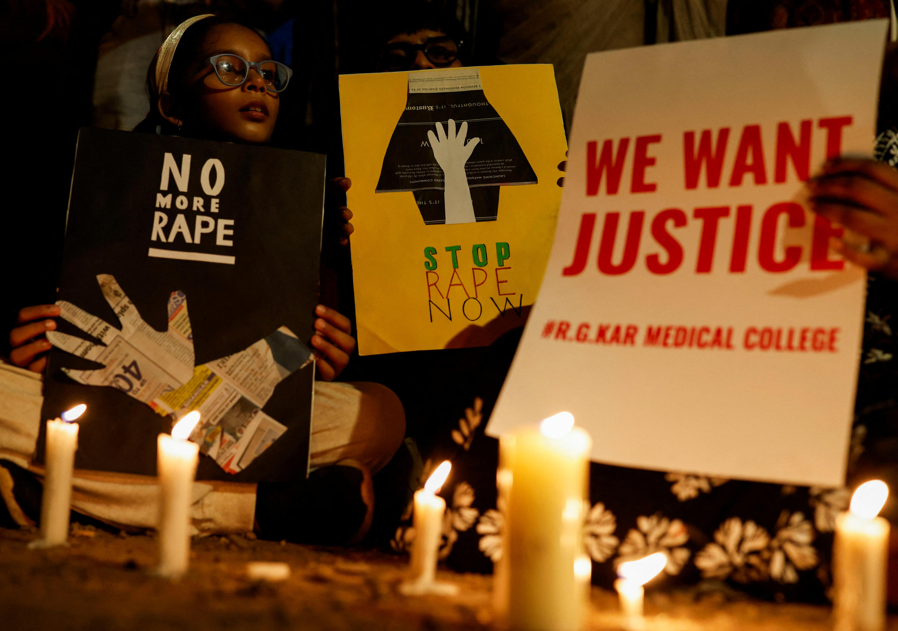 Posters are held aloft during a vigil in Mumbai, India, on Wednesday.