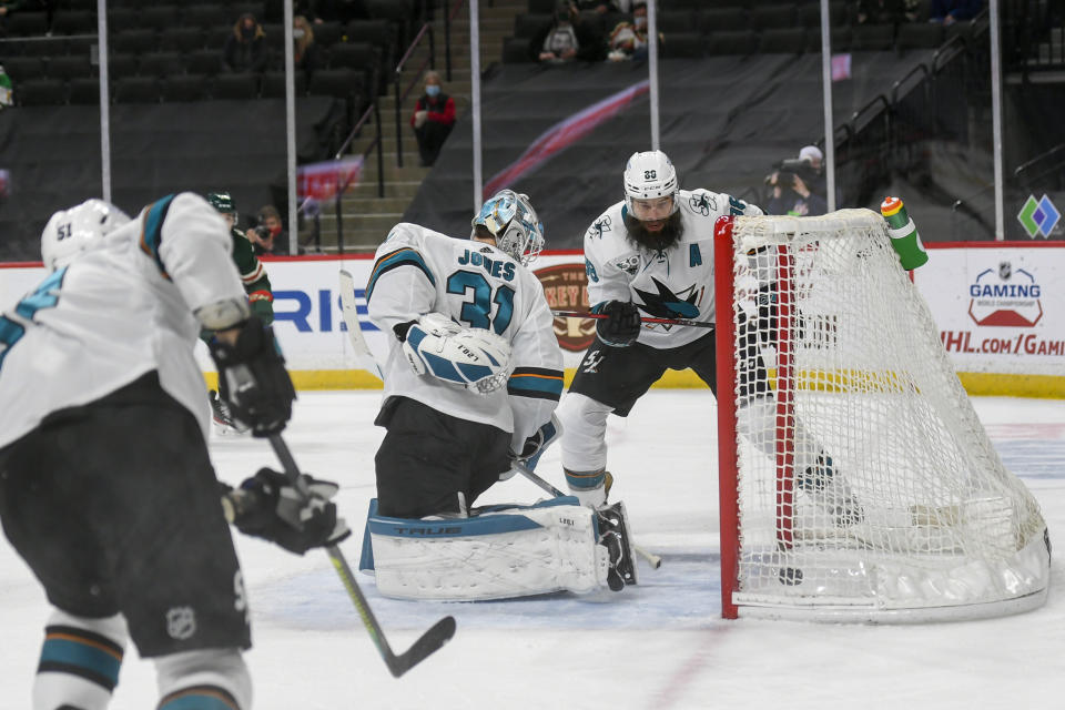 San Jose Sharks goalie Martin Jones, center, and defenseman Brent Burns, right, turn to watch the puck go into the goal after a shot by Minnesota Wild right wing Mats Zuccarello during the first period of an NHL hockey game Saturday, April 17, 2021, in St. Paul, Minn. (AP Photo/Craig Lassig)