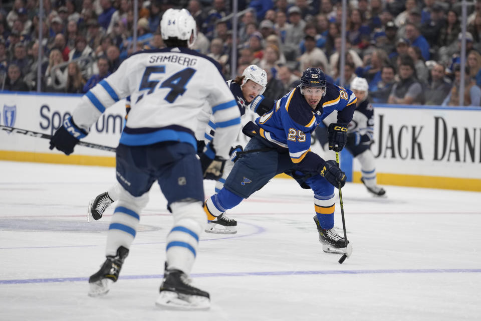 St. Louis Blues' Jordan Kyrou (25) brings the puck down the ice as Winnipeg Jets' Dylan Samberg (54) defends during the second period of an NHL hockey game Tuesday, Nov. 7, 2023, in St. Louis. (AP Photo/Jeff Roberson)