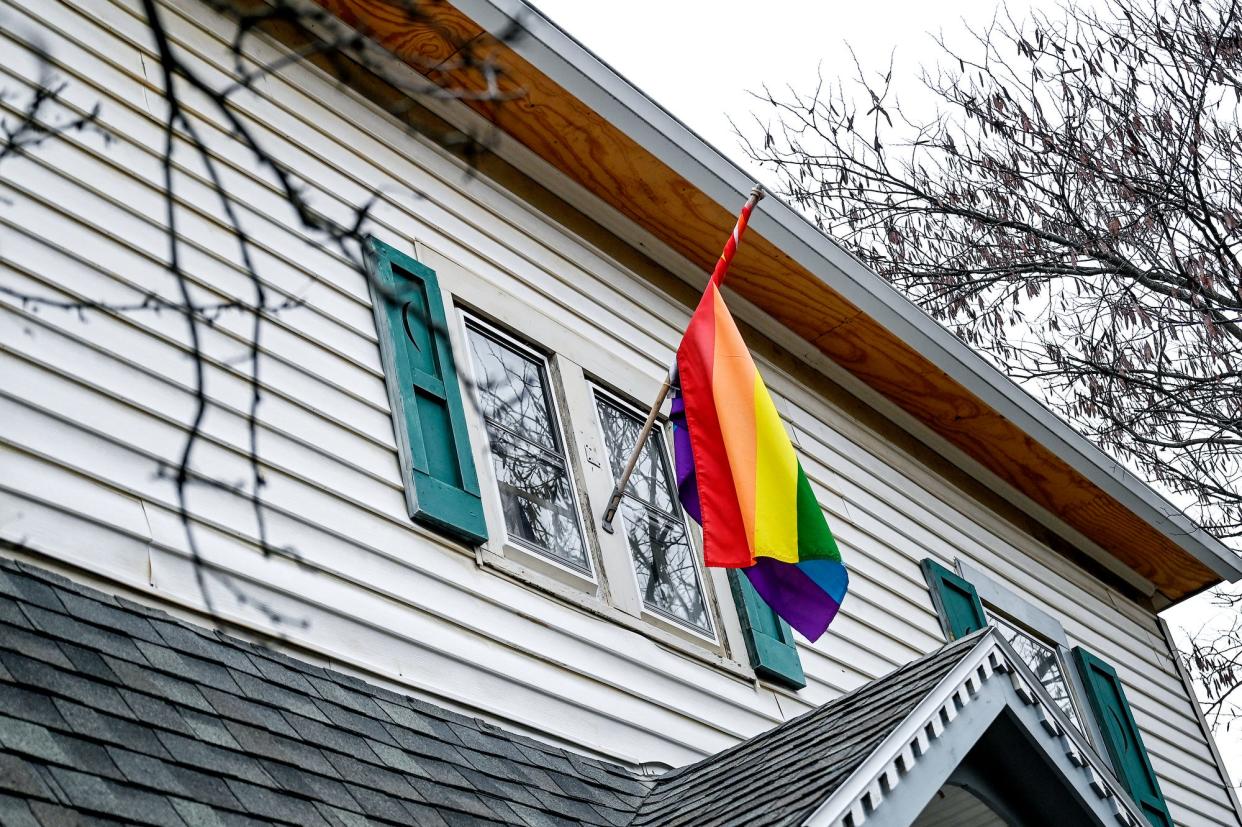 A LGBTQ flag hangs outside the Wheeler's home on Friday, Dec. 9, 2022, in East Lansing, Mich.