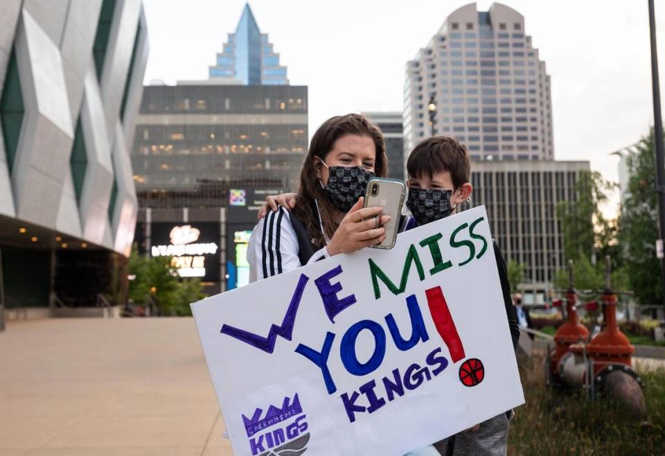 Registered nurse Kaleena Noland and her son, Deion Noland, 8, talk on a video call as they await COVID-19 rapid-test results outside Golden 1 Center before the Sacramento Kings NBA game Tuesday, April 20, 2021. The matchup between the Kings and Minnesota Timberwolves was the first open to fan attendance since the coronavirus pandemic kept them out of Golden 1 Center. “The last year has been pretty crazy, I’m just so thankful for the vaccine,” she said, adding her gratitude for the Kings’ and Sacramento community’s efforts to be able to reopen the arena for limited attendance. “We just brought this for a little inspiration for the Kings, and to cheer them up,” Noland said about the sign he worked on with his mom.