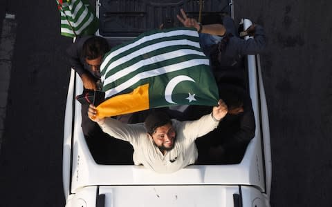 A man waves a Pakistan-administered Kashmir flag as he takes part in Independence Day celebrations in Karachi on August 14, 2019, - Credit: AFP