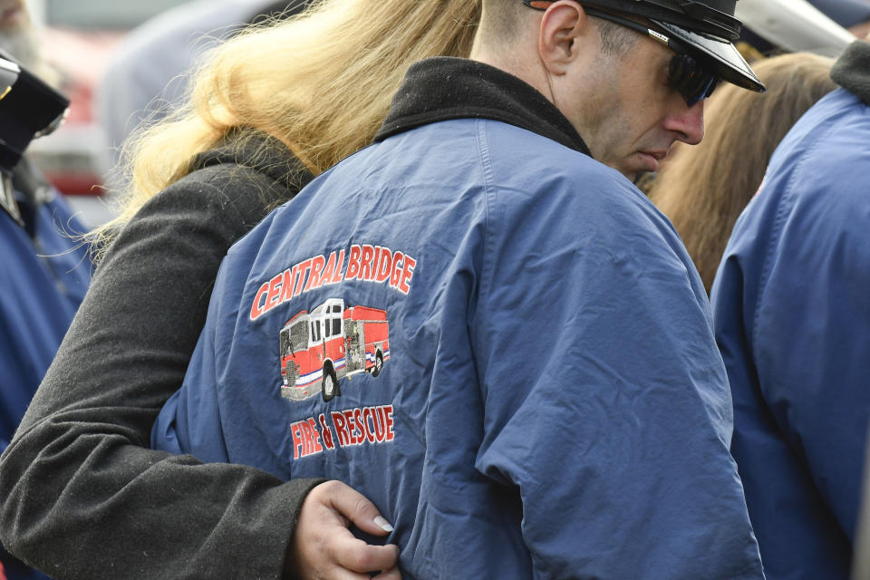 First responders along with family members and friends gather for a memorial unveiling ceremony, on the one year anniversary of the Schoharie limousine crash that killed 20 people next to the Apple Barrel Restaurant Saturday, Oct. 5, 2019, in Schoharie, N.Y. (AP Photo/Hans Pennink)