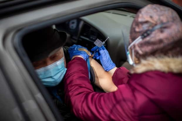 Health-care workers provide COVID-19 Pfizer vaccines at a drive-thru clinic in Central Park in Burnaby, B.C., on March 26.  (Ben Nelms/CBC - image credit)