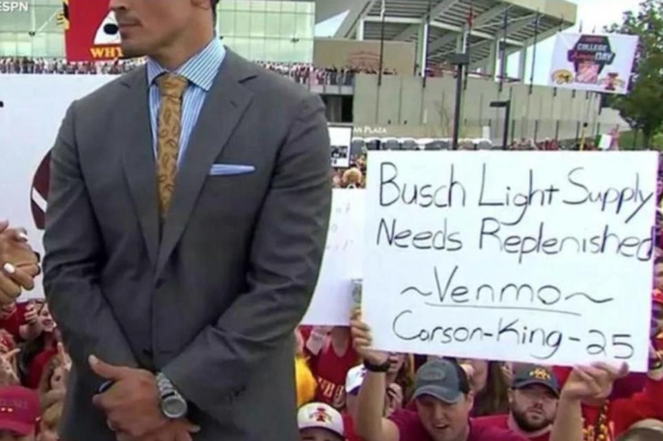 Carson King holds up a sign for the ESPN cameras asking for beer money. (via ESPN)