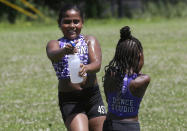 Dancers from the 4 Star Dance Studio Jazmyn Cawley-Zayas, 9, left, and Kymora McKoy-Johnson, 6, right, both of Boston, spray one another while cooling down after dancing in the Roxbury Unity Parade, Sunday, July 21, 2019, in Boston's Roxbury neighborhood. Temperatures during the parade reached the 90s. (AP Photo/Steven Senne)