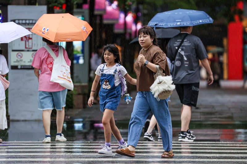 對流雲系發展旺盛  氣象署豪雨、大雨特報 對流雲系發展旺盛，中央氣象署24日陸續發布豪雨特 報及大雷雨訊息，台北市信義區午後降下大雨，沒有 撐傘的民眾在雨中快步過馬路。 中央社記者鄭清元攝  113年6月24日 