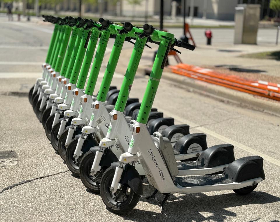 Lime electric scooters are lined up and ready for use on the corner of North Water Street and East Kilbourn Avenue in Milwaukee on Friday, May 17, 2024.