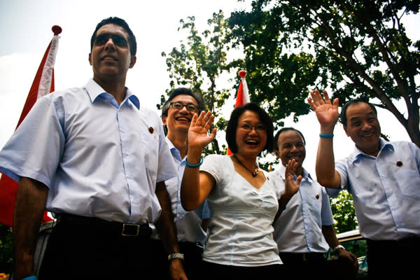 The new Aljunied GRC team from the Workers' Party waves at residents at the start of their thank-you procession. (Yahoo!/Liyana Low)