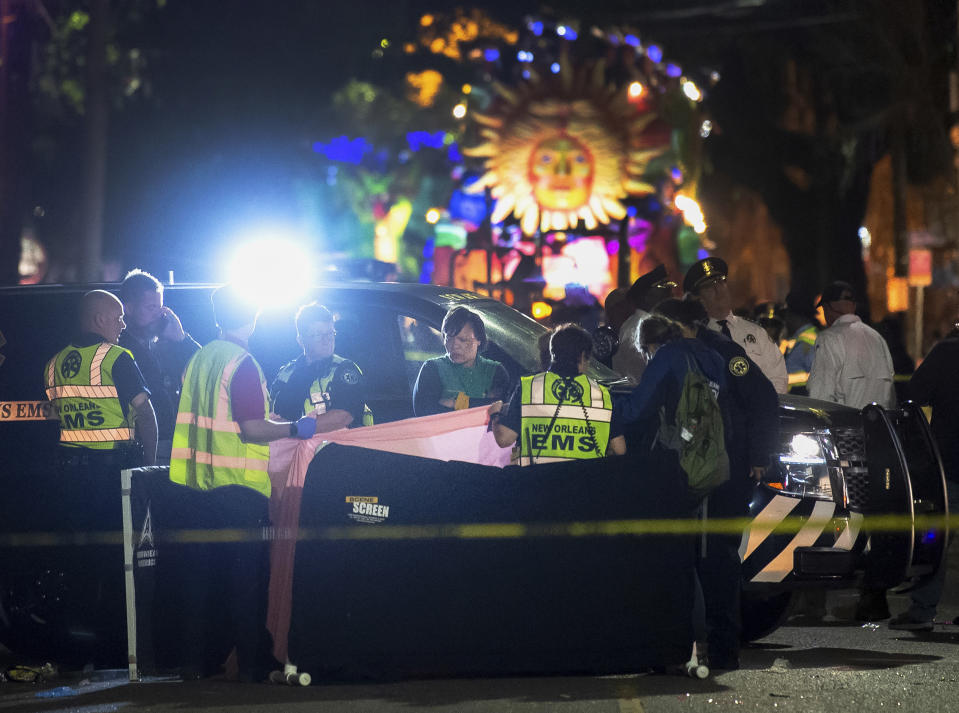New Orleans Mayor LaToya Cantrell, center, looks over the covered body on Magazine Street as medics work the scene where the woman was run over by a float during the Mystic Krewe of Nyx parade in Mardi Gras celebrations in New Orleans on Wednesday, Feb. 19, 2020. (Chris Granger/The Advocate via AP)