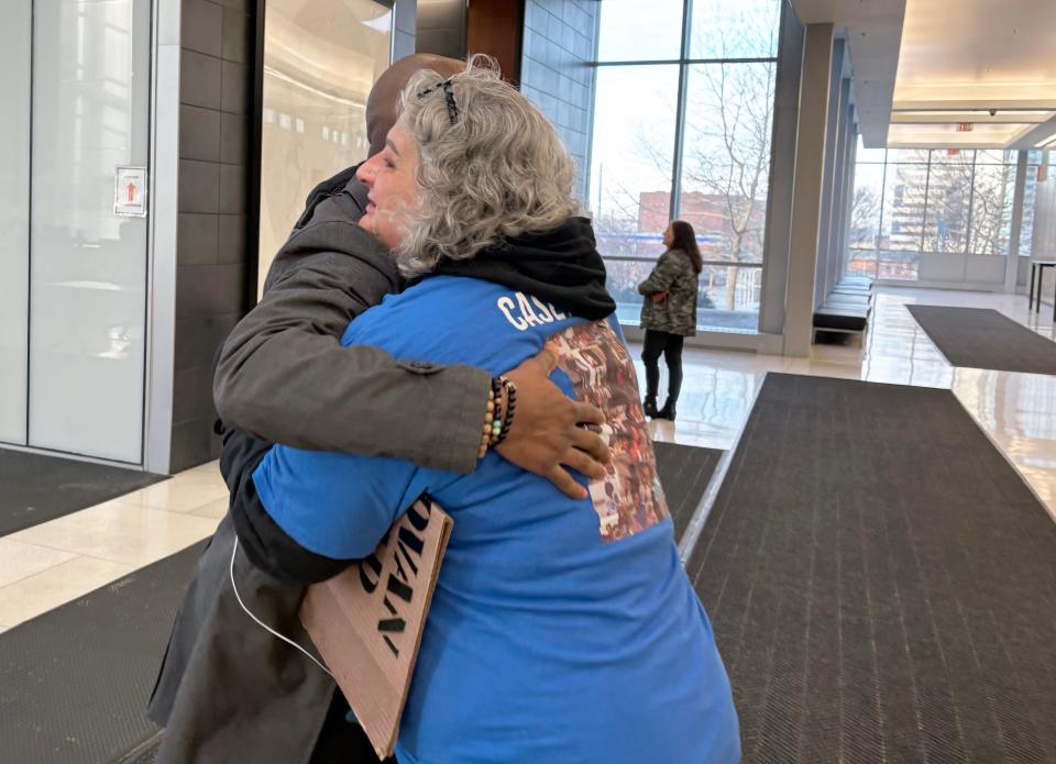Rebecca Duran hugs attorney Sean Walton in the hallway of the Franklin County Court of Common Pleas on Thursday. Duran was holding a sign that read, "Justice for Casey Goodson. Convict Jason Meade." Duran is the mother of Donovan Lewis, who was shot and killed by a Columbus police officer in August 2022.