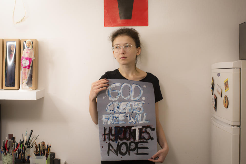 Eleonora Buczynska poses for a portrait holding the banner she takes to protests in Warsaw, Poland, Tuesday, Nov. 17, 2020. The rage of Polish women, and many men as well, erupted onto the streets across the country, growing into the largest protest movement in the three decades since communism fell. (AP Photo/Agata Grzybowska)