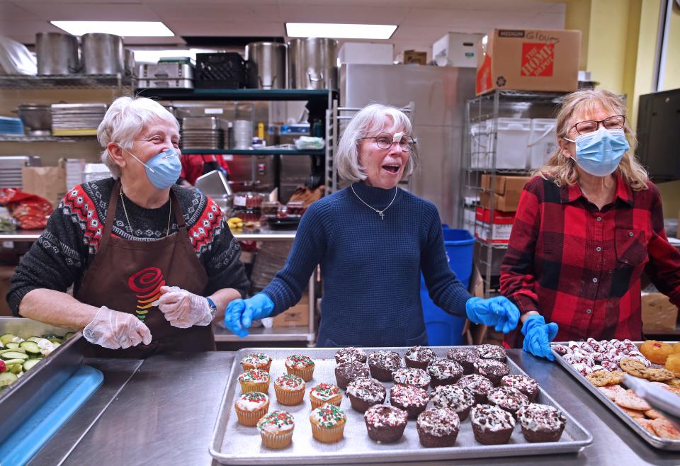 Volunteers Sue Ellen Christman, from left, Shelia Klopp, and Francine Yerasha, rshare holiday  memories in between serving at St. Ben’s Community Meal.