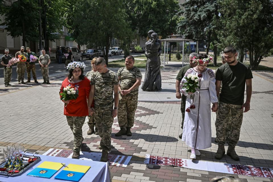 Two pairs of Ukrainian soldiers get married in Druzhivka, eastern Ukraine on 12 June, 2022 (AFP via Getty Images)