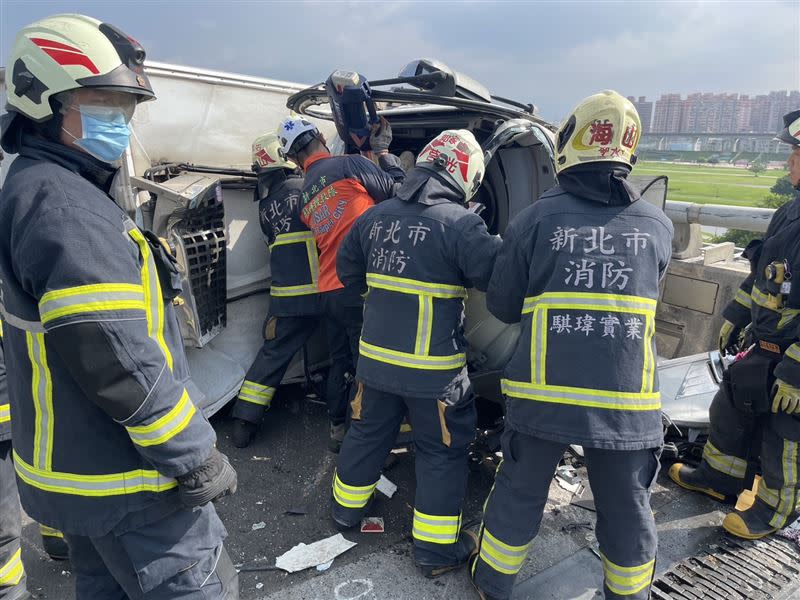 消防隊搶救受困的小貨車駕駛擦撞小貨車的BMW。（圖／翻攝畫面）