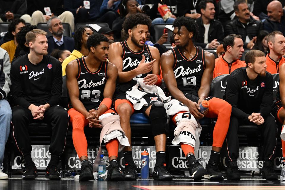 Detroit Pistons guard Cade Cunningham (2) (center) talks with guard Jaden Ivey (23) (left) and center James Wiseman (13) on the bench in the first quarter of their game against the Boston Celtics at Little Caesars Arena in Detroit on Friday, March 22, 2024.