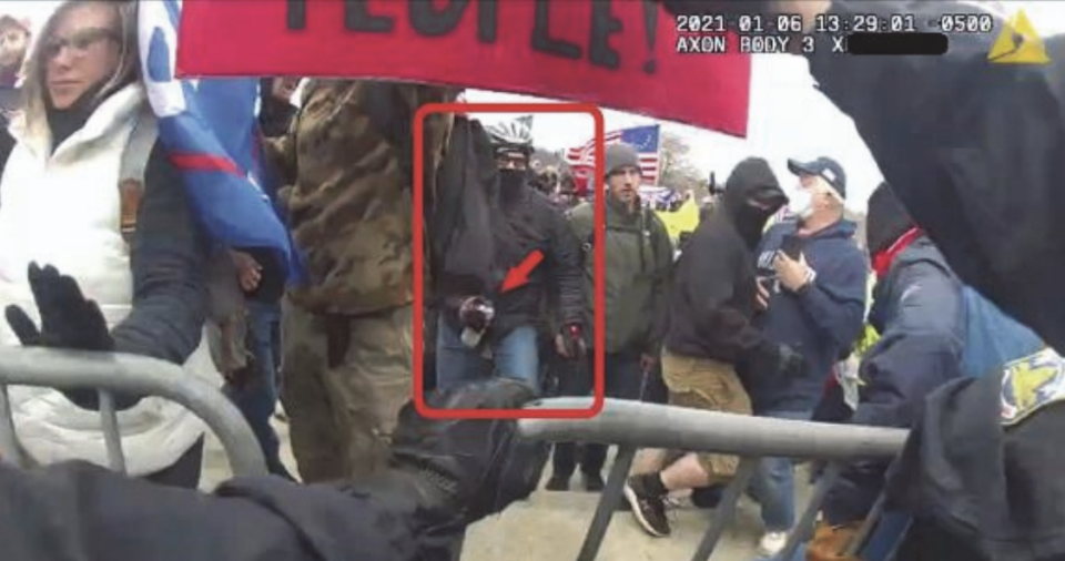 A screenshot of a body camera worn by a police officer outside the Capitol shows what prosecutors say is Pete Moloney carrying a can of insecticide after spraying it at officers on Jan. 6, 2023. / Credit: Justice Department