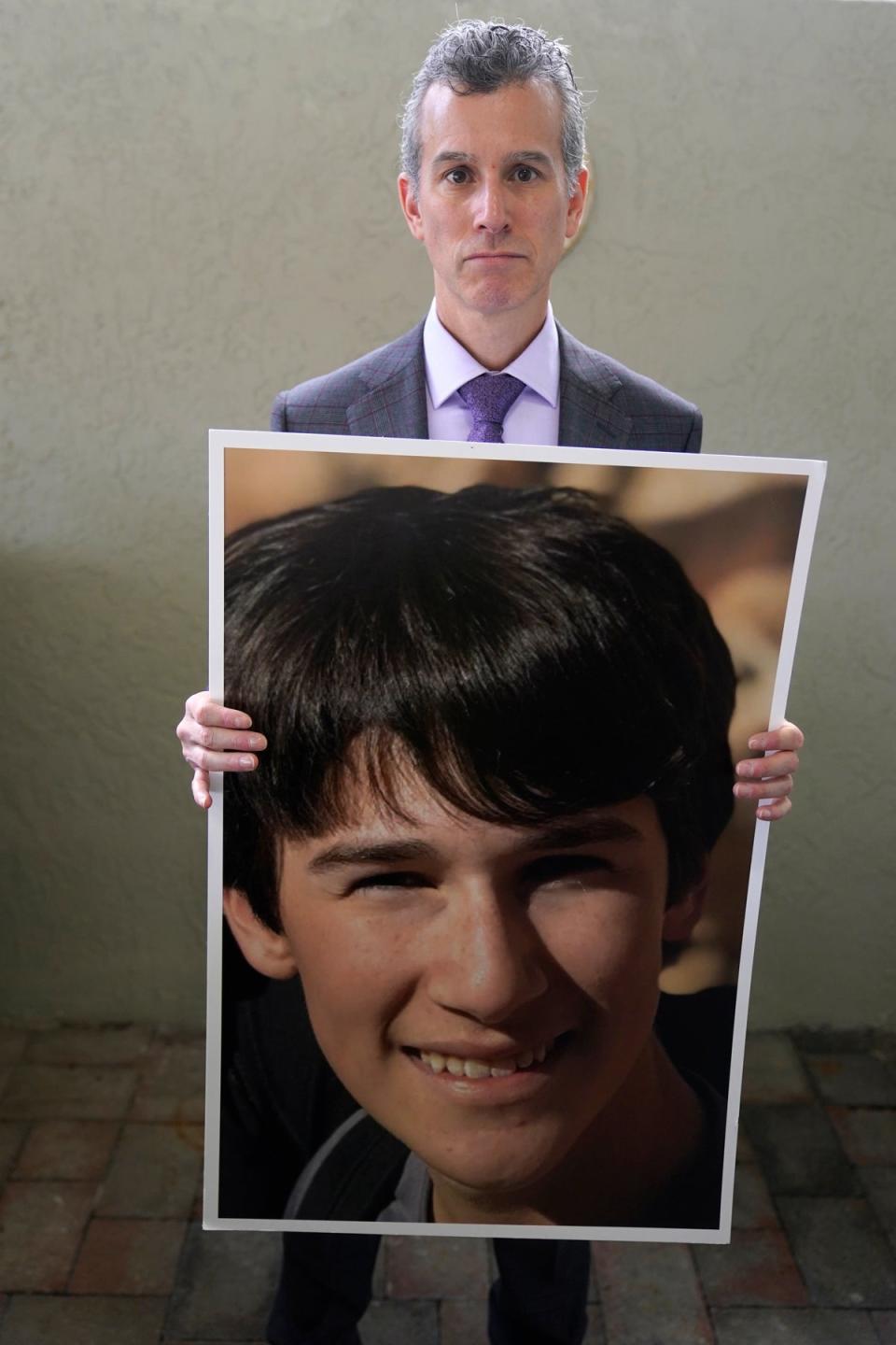 Max Schachter holds up a photo of his 14-year-old son Alex (Copyright 2023 The Associated Press. All rights reserved)