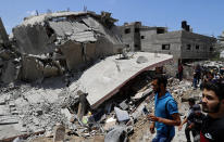 People inspect the rubble of a destroyed residential building which was hit by Israeli airstrikes, in Gaza City, Wednesday, May 12, 2021. (AP Photo/Adel Hana)