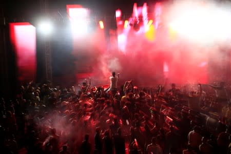 Young people dance as they attend electronic music concert with western tunes at closed Hall in Shaab Stadium for the first time in Baghdad