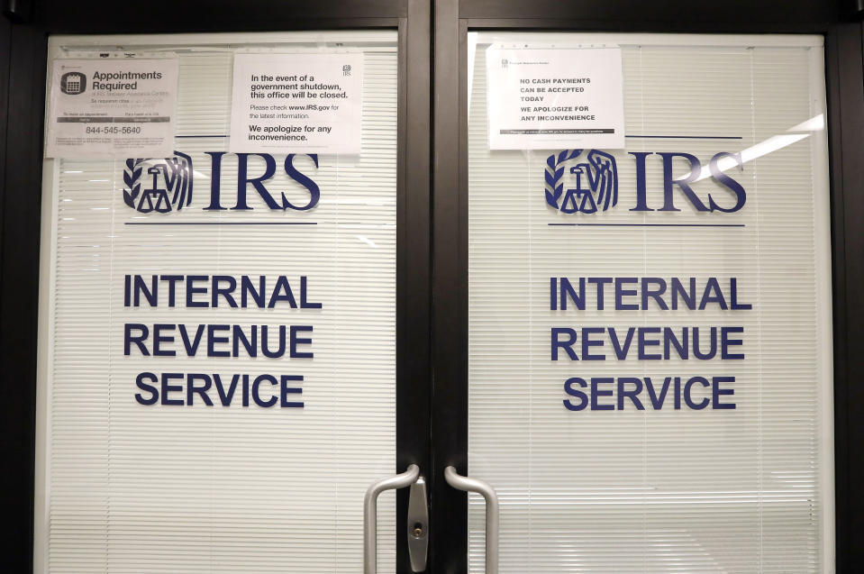 Doors at the Internal Revenue Service (IRS) in the Henry M. Jackson Federal Building are locked and covered with blinds as a sign posted advises that the office will be closed during the partial government shutdown Wednesday, Jan. 16, 2019, in Seattle. The shutdown is in its fourth week with no end in sight. (AP Photo/Elaine Thompson)