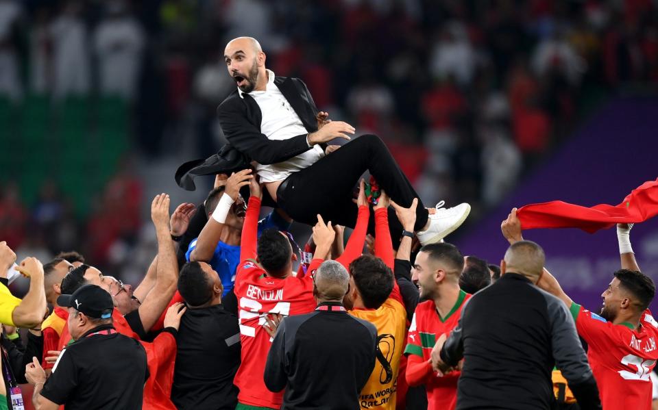 Head coach Walid Regragui was hoisted aloft by his players after their history-making victory - Justin Setterfield/Getty Images