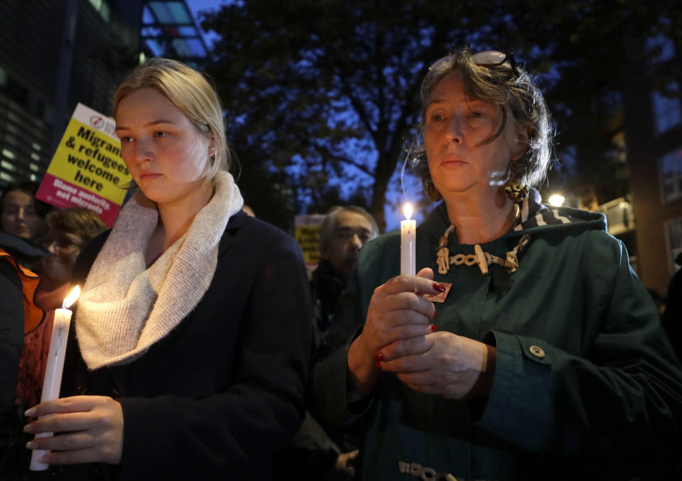 Demonstrators hold banners and candles during a vigil for the 39 lorry victims, outside the Home Office in London, Thursday, Oct. 24, 2019. Authorities found 39 people dead in a truck in an industrial park in England on Wednesday and arrested the driver on suspicion of murder in one of Britain's worst human-smuggling tragedies. (AP Photo/Kirsty Wigglesworth)