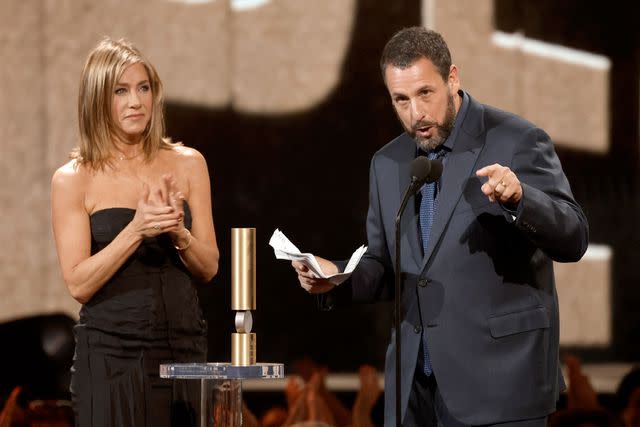 <p>Trae Patton/NBC via Getty</p> Jennifer Aniston presents Adam Sandler with the People's Icon Award onstage during the 2024 People's Choice Awards