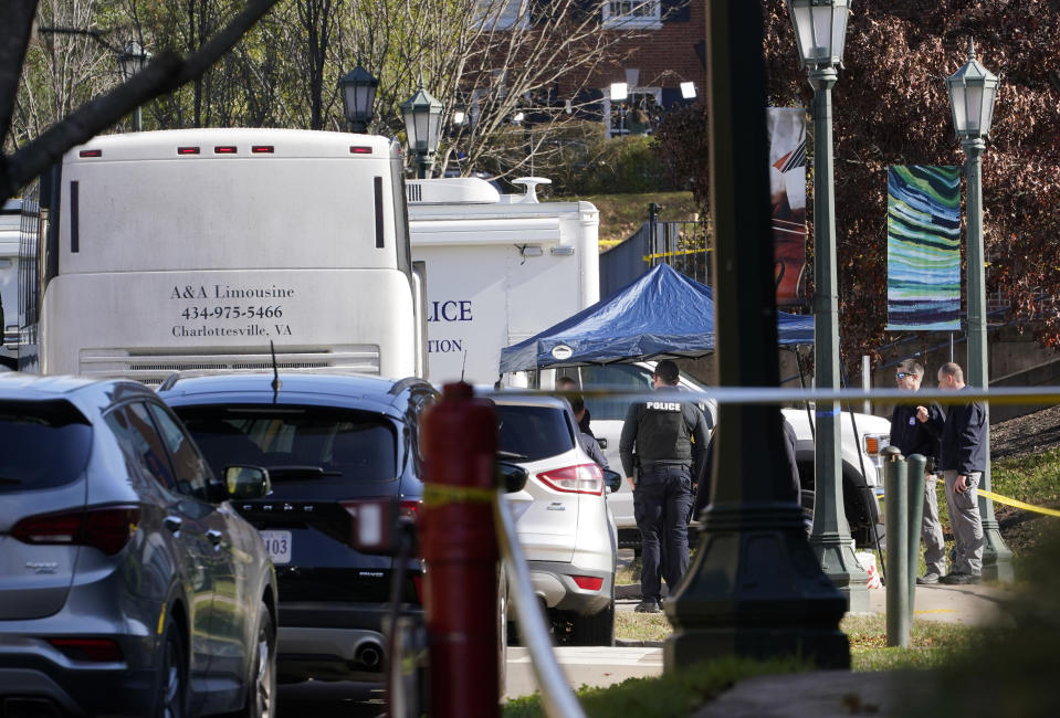 Police investigators work around a bus which is believed to be the site of an overnight shooting on the grounds of the University of Virginia Monday, Nov. 14, 2022 in Charlottesville. Va. (AP Photo/Steve Helber)