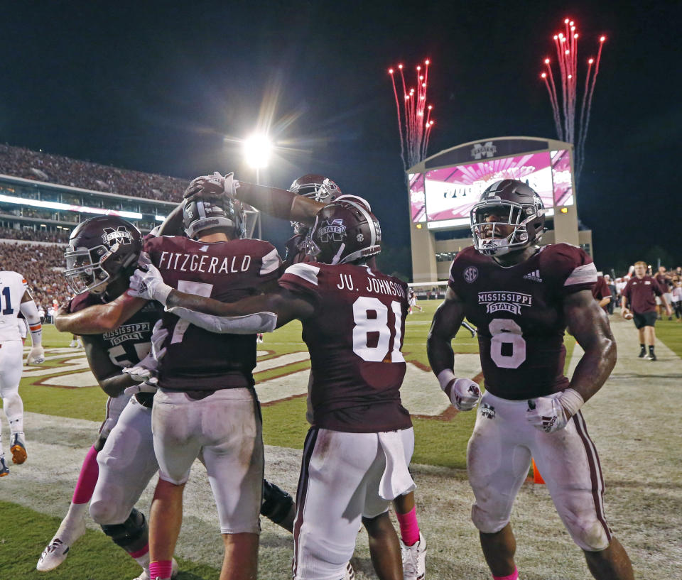 Mississippi State quarterback Nick Fitzgerald (7) and teammates celebrate his 21-yard touchdown run against Auburn as fireworks go off in the background during an NCAA college football game in Starkville, Miss., Saturday, Oct. 6 2018. Mississippi State won 23-9. (AP Photo/Rogelio V. Solis)