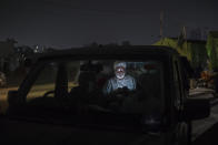 Farmer Avtar Singh, 70, looks at his mobile phone as he sits inside his SUV parked on a highway during a protest at the Delhi-Haryana state border, India, Wednesday, Dec. 2, 2020. The convoy of trucks, trailers and tractors stretches for at least three kilometers (1.8 miles). It’s a siege of sorts and the mood among the protesting farmers is boisterous. Their rallying call is “Inquilab Zindabad” (“Long live the revolution”). (AP Photo/Altaf Qadri)