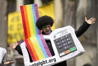 An LGBT activist wearing a costume in the likeness of an electronic voting machine gathers with others after the reading of two manifestos defending the nation's democratic institutions and electronic voting system outside the Faculty of Law at Sao Paulo University in Sao Paulo, Brazil, Thursday, Aug. 11, 2022. The two documents are inspired by the original "Letter to the Brazilians" from 1977 denouncing the brutal military dictatorship and calling for a prompt return of the rule of law. (AP Photo/Andre Penner)