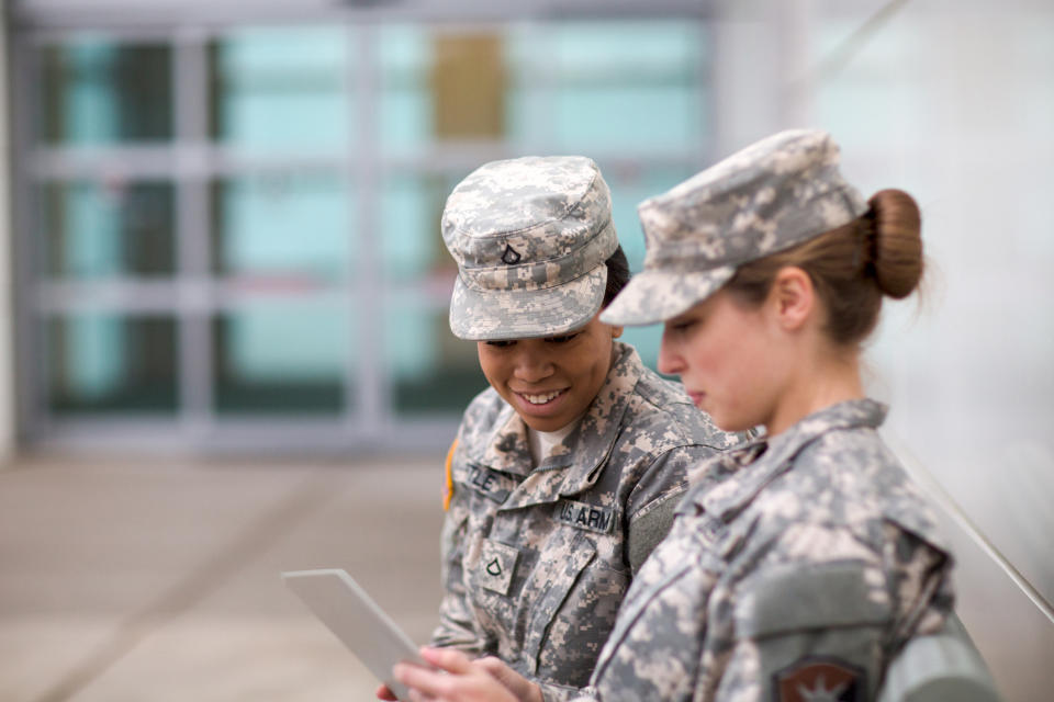 Two young female US army members looking at a sheet